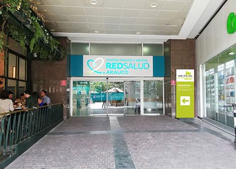 Médico especialista revisando ficha clínica con paciente en consulta ambulatoria del Centro Médico y Dental RedSalud Arauco, ubicado en el Boulevard del Mall Parque Arauco, Santiago