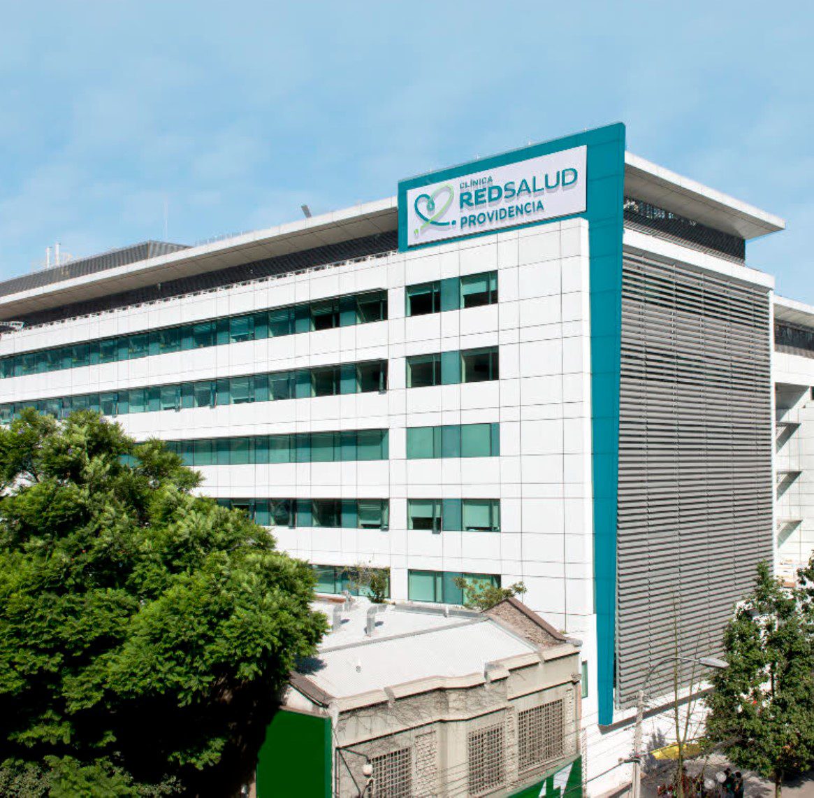 Médico especialista revisando resultados de exámenes con un paciente adulto en una consulta privada de Clínica RedSalud Providencia
