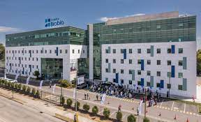Médico especialista revisando resultados de exámenes con un paciente en una consulta privada de Clínica BioBío, Concepción