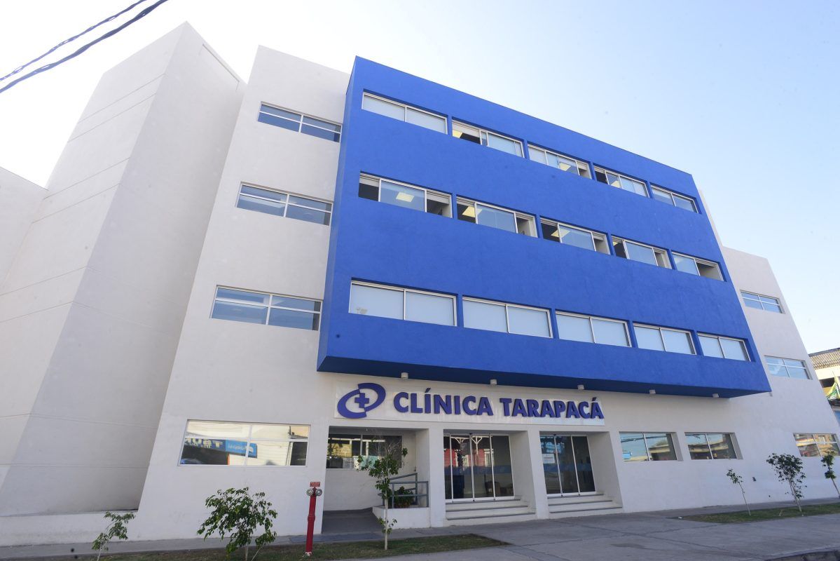 Médico especialista revisando resultados de exámenes con un paciente en consulta privada de Clínica Tarapacá en Iquique