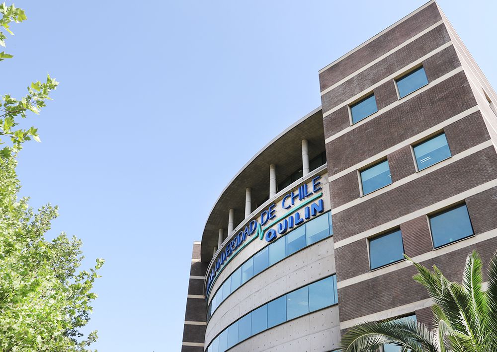 Fachada del edificio de Clínica Quilín en Peñalolén, con pacientes ingresando al centro médico universitario