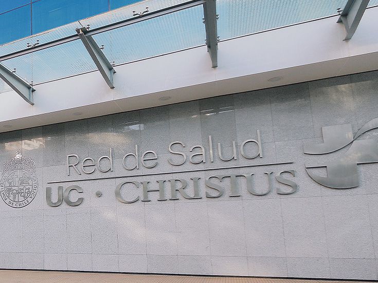 Médico de la red UC Christus revisando ficha clínica con paciente en consulta privada de hospital universitario